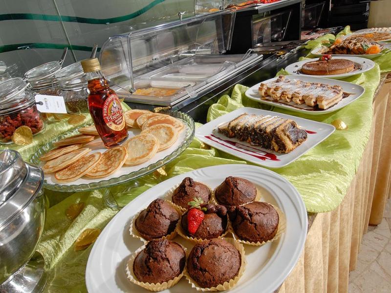 Buffet dolce con muffin, pancake, sciroppo d'acero e dolci vari.